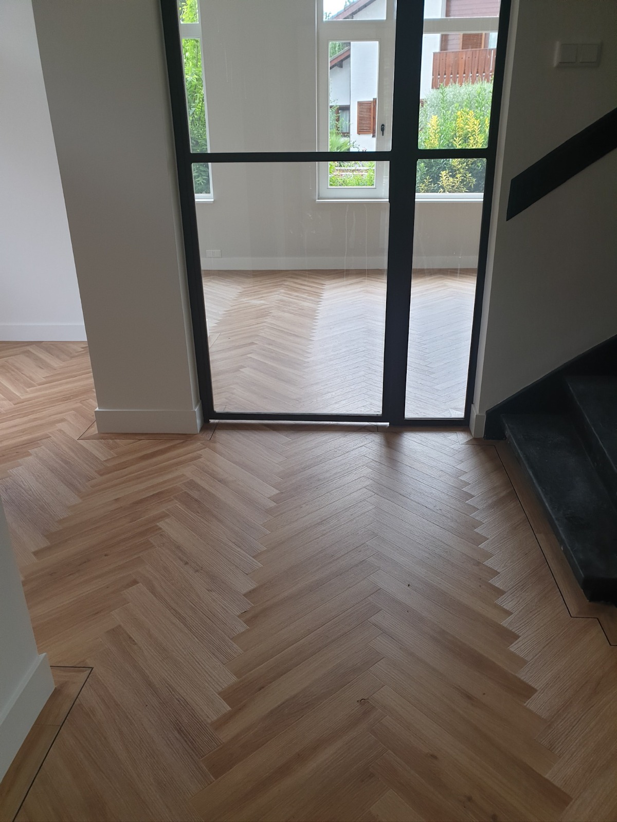 Visgraat PVC-vloer in een hal met stalen taatsdeur